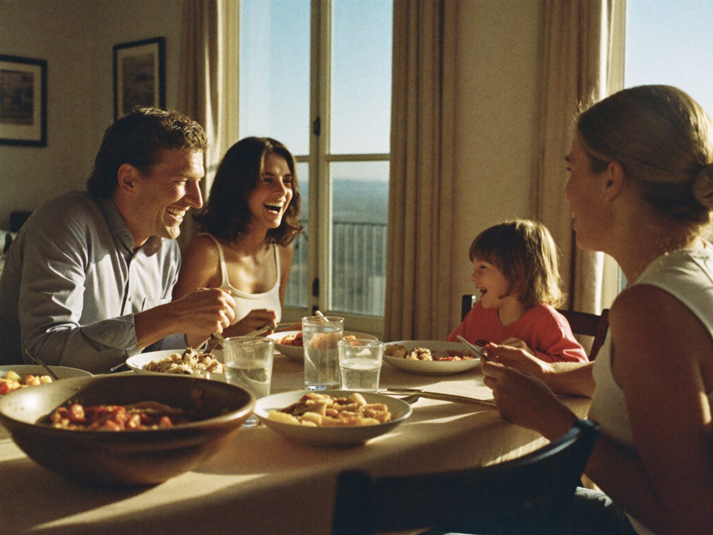Business owner present at a relaxed family dinner, fully off the clock