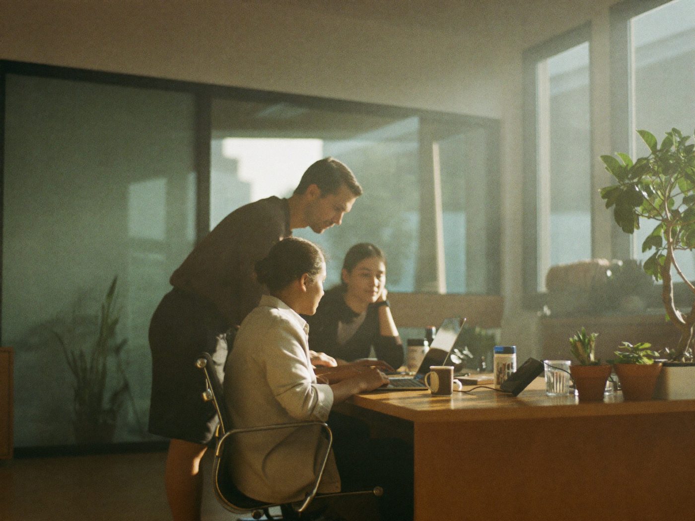 A small team collaborating calmly in a bright modern office, unblocked